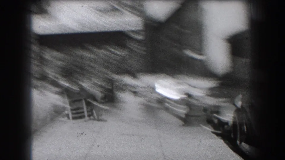 Soft 8mm view of a Reading sidewalk near Hotel Berkshire, with parked automobiles, building steps, and a passerby near the right edge.
