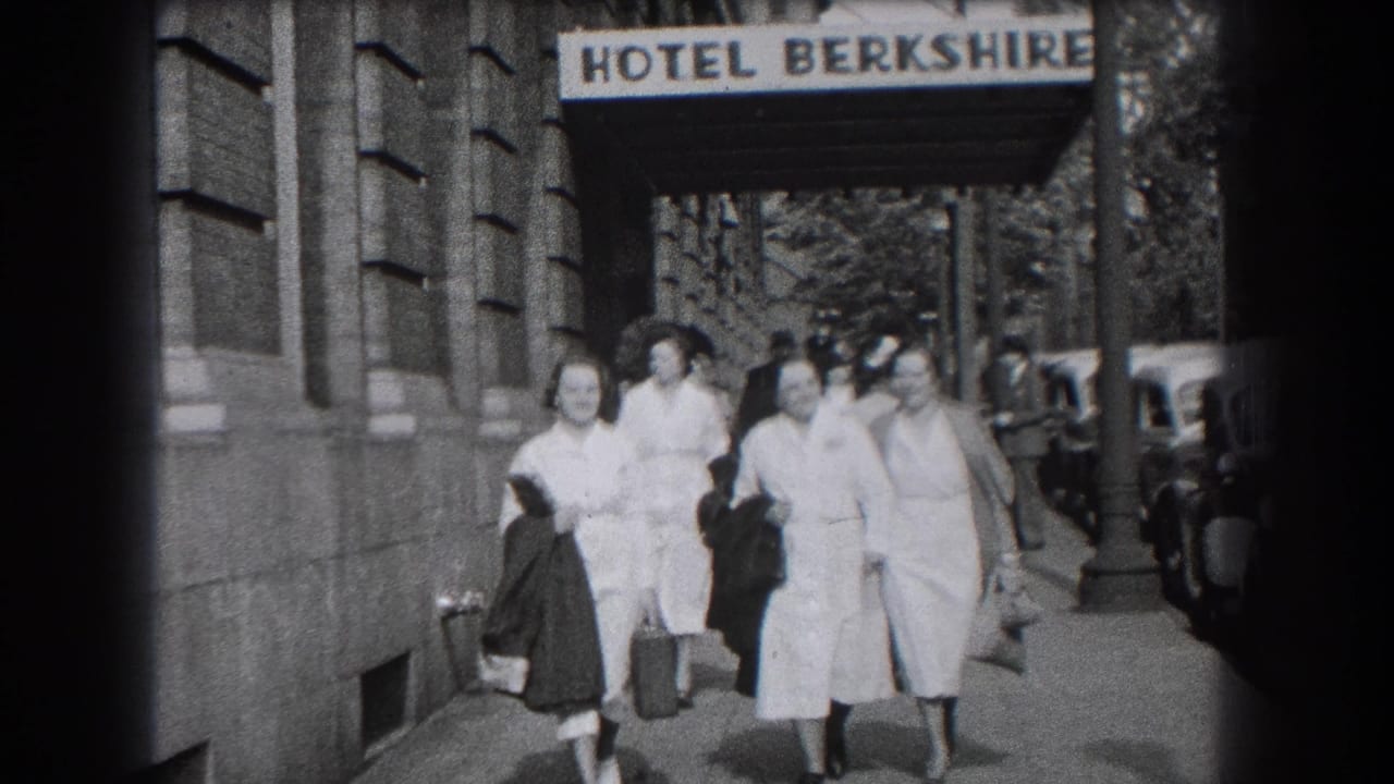 Closer 1938 home-movie view of women in nurse-style uniforms walking together beside a stone building in Reading, Pennsylvania.