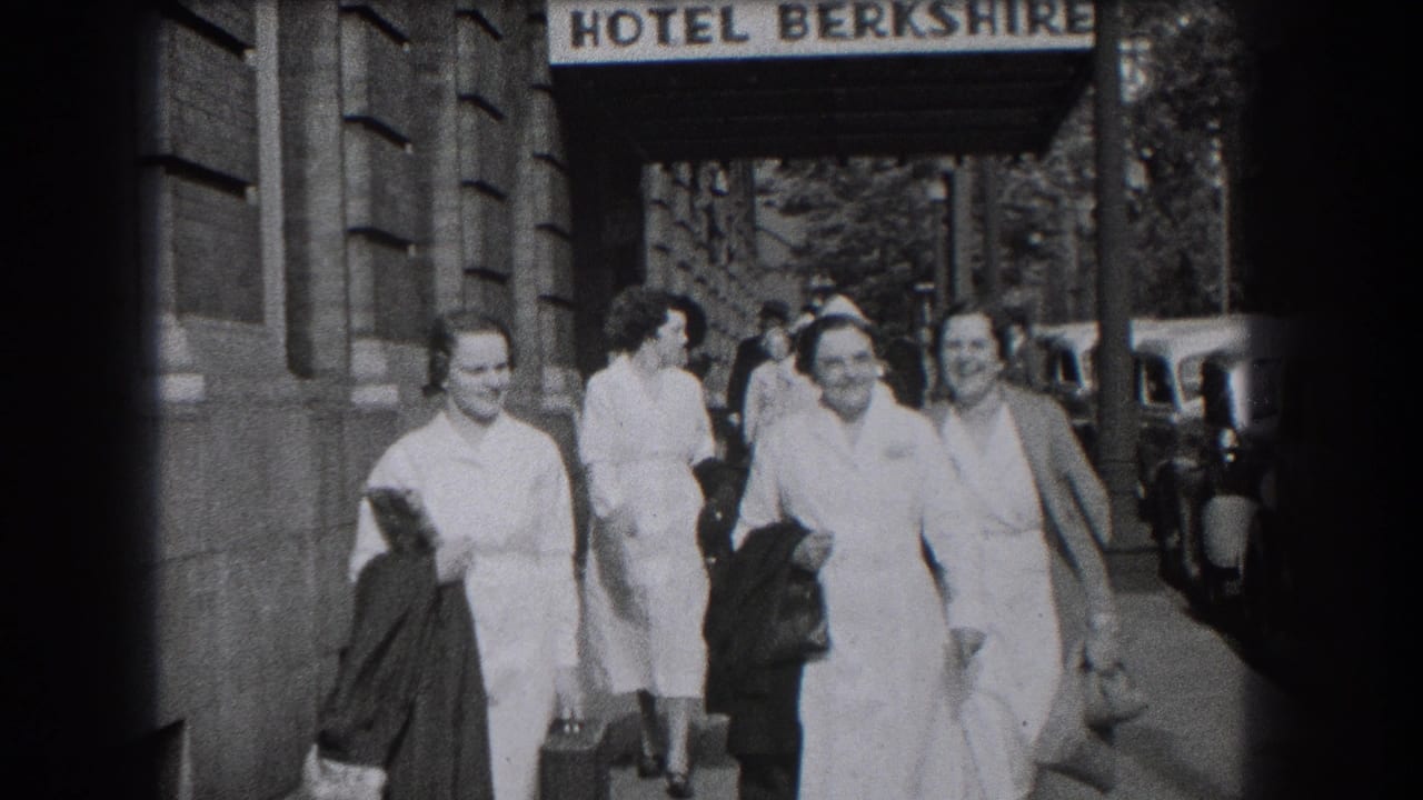 Nurses in white uniforms walk past the Hotel Berkshire entrance on a city sidewalk.