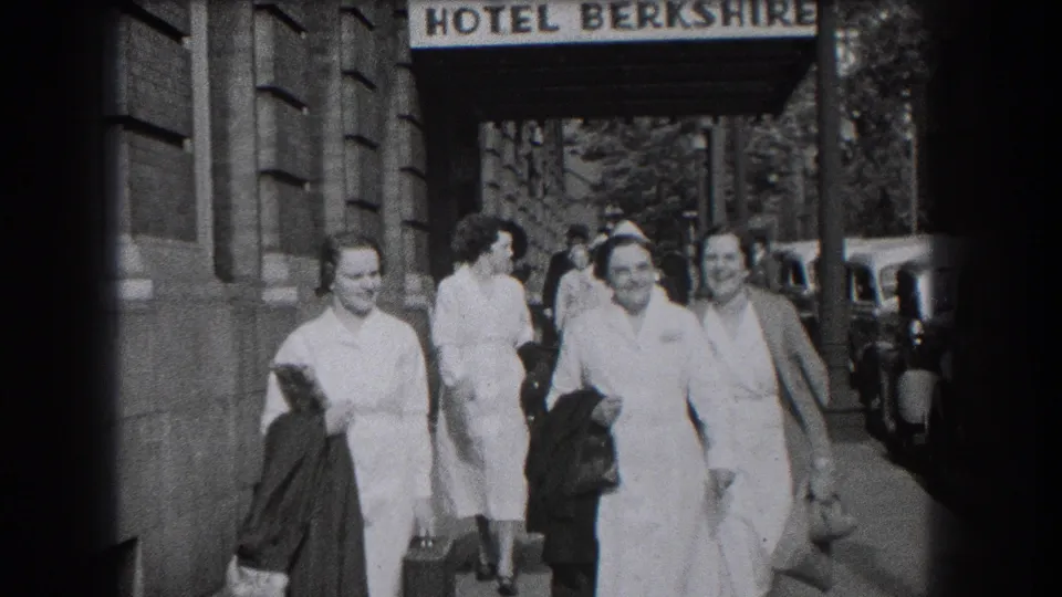In Reading, Pennsylvania, nurses in white uniforms walk and smile outside the Hotel Berkshire in 1938 home-movie footage.