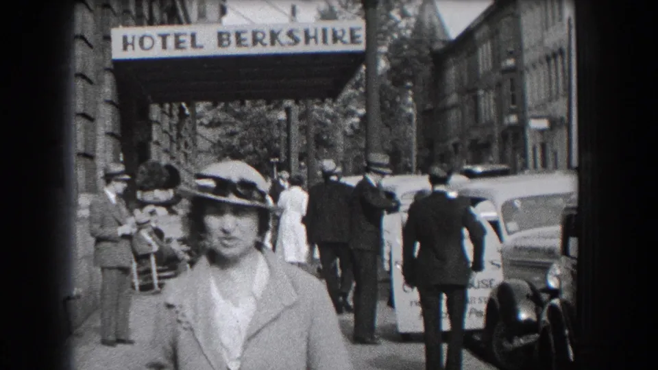 1938 Reading sidewalk scene with a woman close to camera, the Hotel Berkshire sign above, and delivery activity near parked vehicles.
