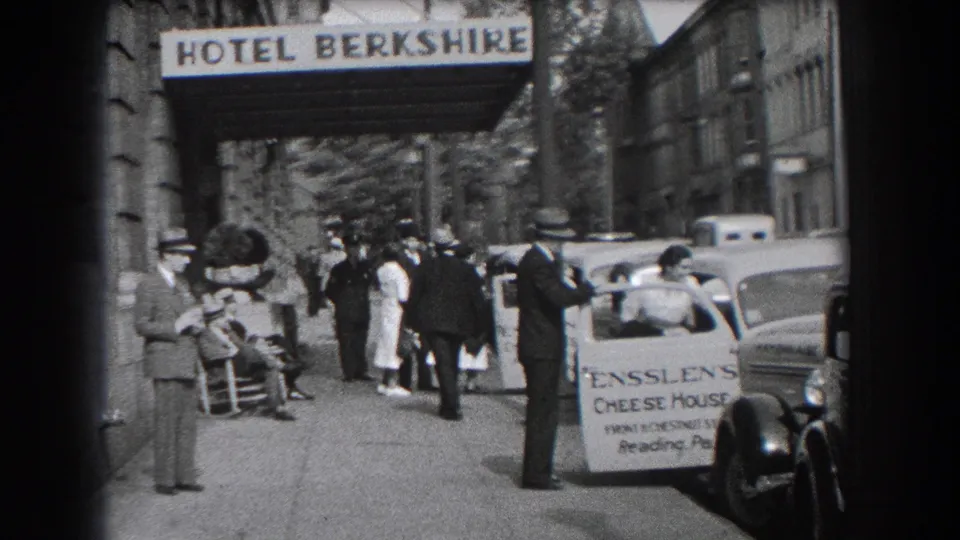 1938 Reading, Pennsylvania street view outside Hotel Berkshire with pedestrians, parked cars, and an Ensslen's Cheese House sign.