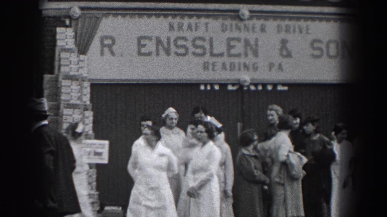 1938 Reading, Pennsylvania home-movie frame showing adults gathered outside R. Ensslen & Sons, including women in white uniforms and men in hats.