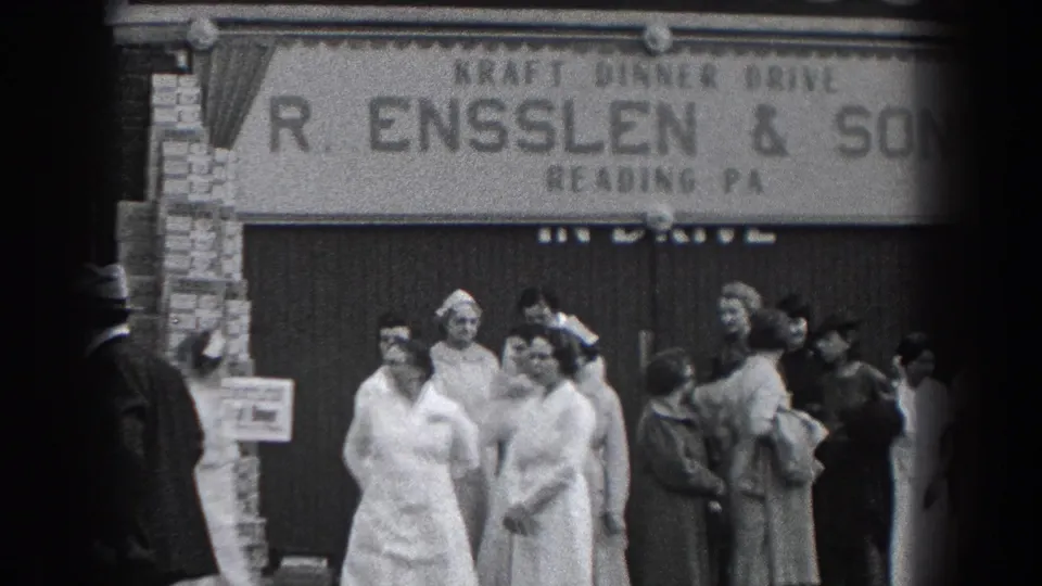 1938 Reading, Pennsylvania home-movie frame showing adults gathered outside R. Ensslen & Sons, including women in white uniforms and men in hats.