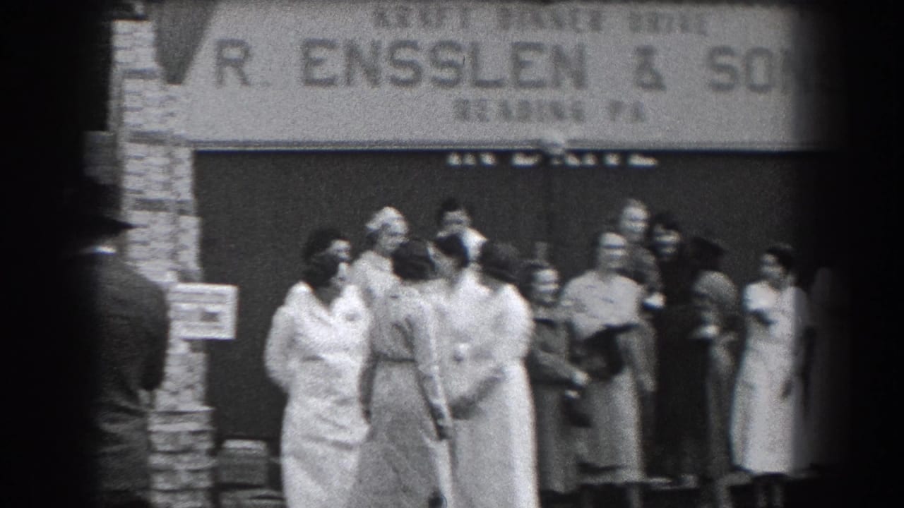 Adults stand and talk outside the R. Ensslen & Sons storefront.