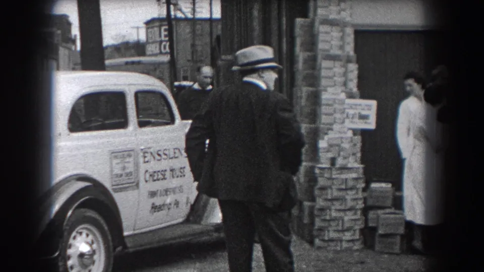 The 1938 Reading street scene shows a marked cheese delivery car, stacked boxes, and adults in coats gathered at a storefront entrance.