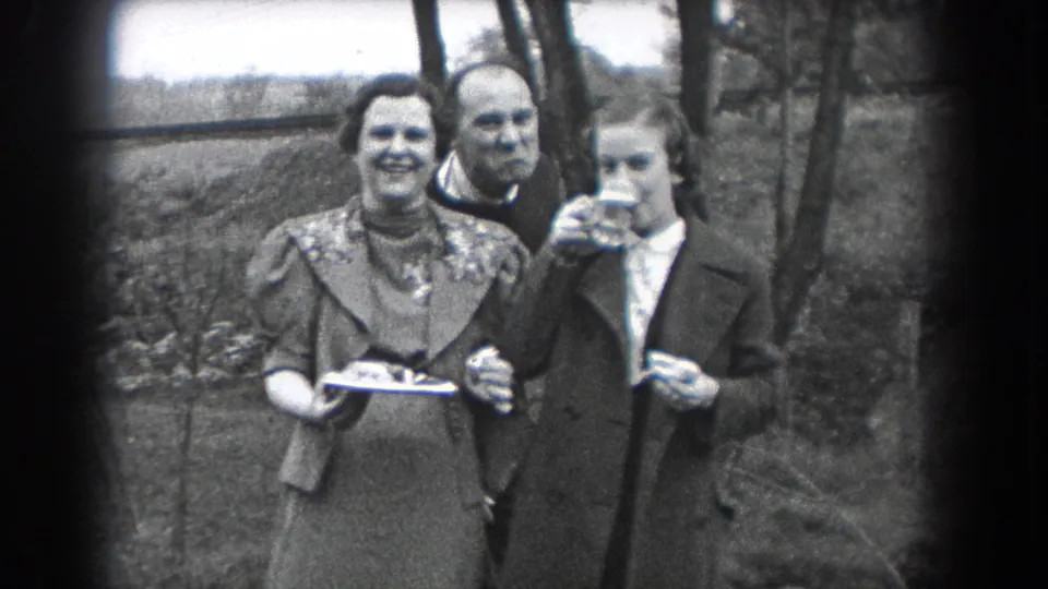 Three adults appear outdoors in Reading, Pennsylvania, with one woman raising a glass as the others face the camera.