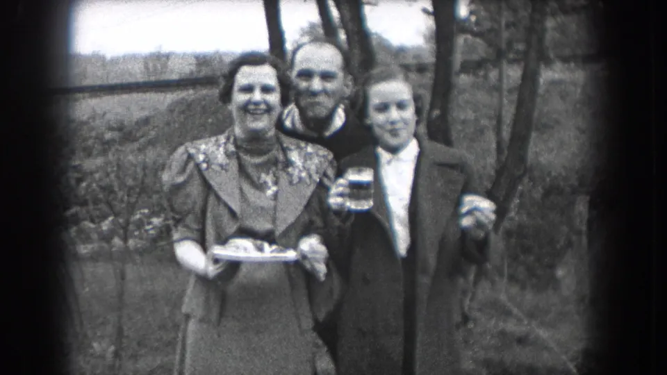Three adults in 1938 Reading, Pennsylvania stand close together outdoors, smiling toward the 8mm camera with drinks and a tray.