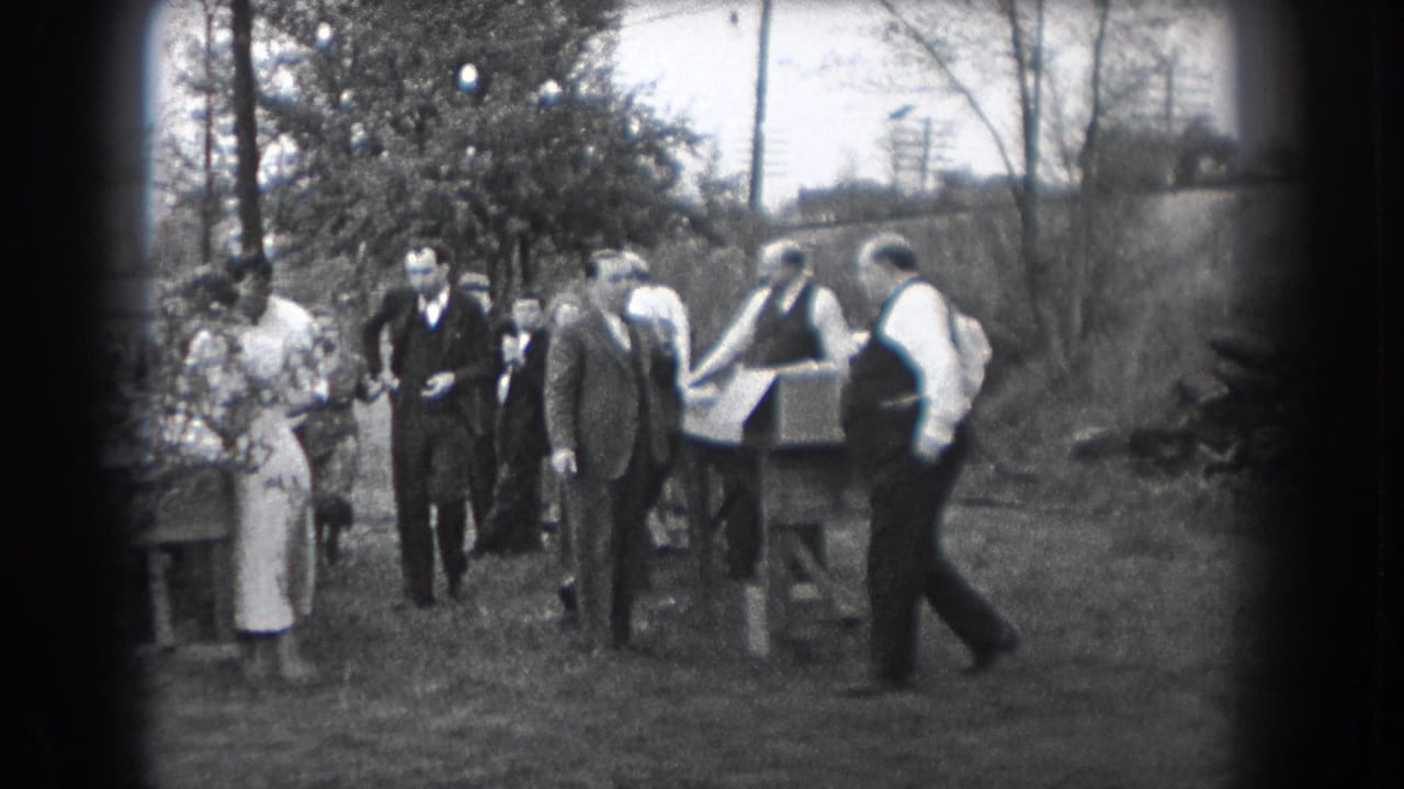 In Reading, Pennsylvania home-movie footage from 1938, adults in suits and dresses stand near an outdoor table on grass.