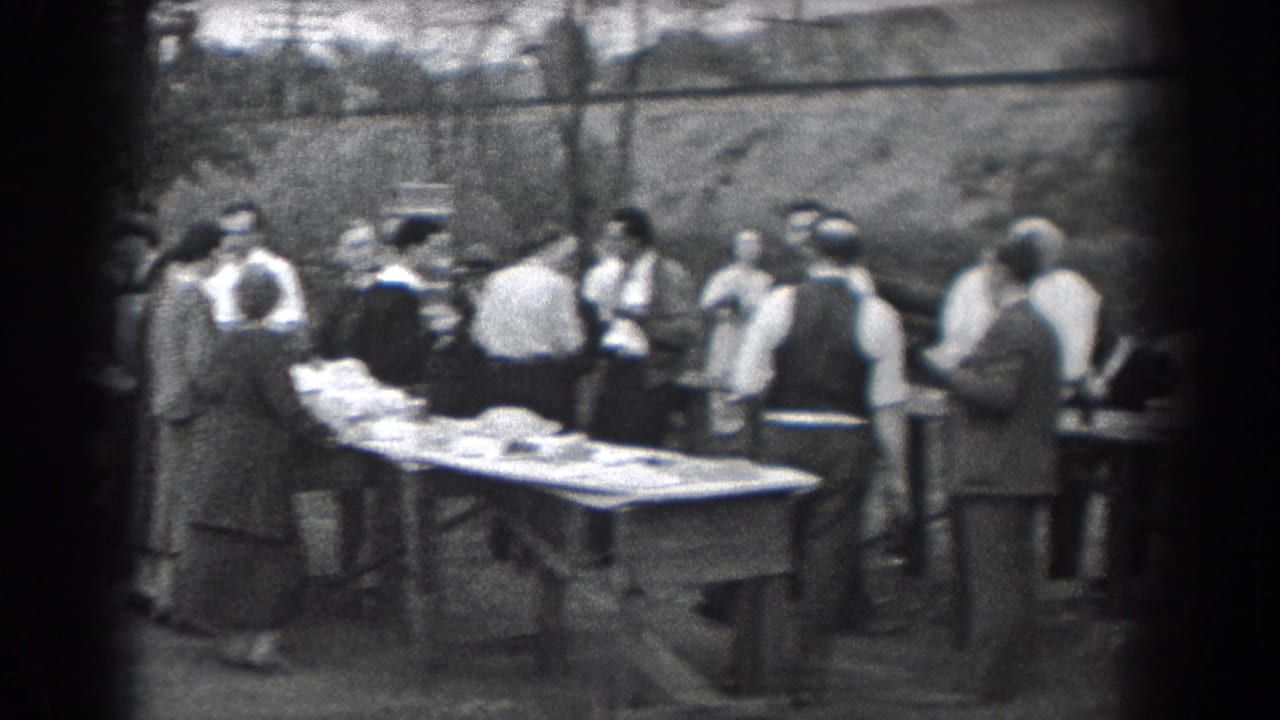 Outdoor Reading, Pennsylvania gathering in 1938, with adults in shirts, vests, coats, and skirts beside tables of food.