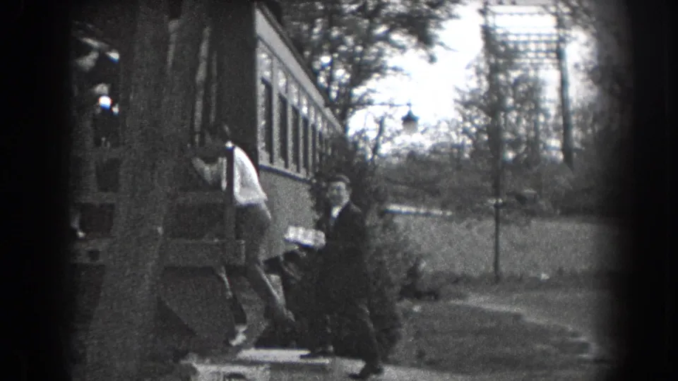 In Reading, Pennsylvania home-movie footage from 1938, two men stand by a house exterior as one carries a cake or tray.