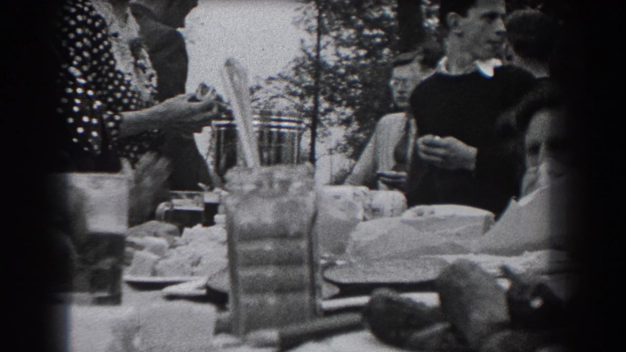 1938 Reading, Pennsylvania home-movie frame of adults at an outdoor meal, with a woman in a polka-dot dress near a table of dishes.