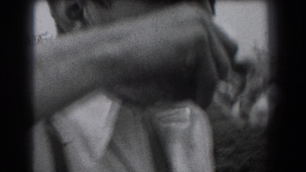 In 1938 Reading, Pennsylvania home-movie footage, a man in a white shirt begins drinking from a glass bottle outdoors.