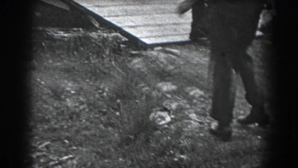 Two adults appear to dance or turn together on a grassy path in the 1938 Reading, Pennsylvania home-movie footage.