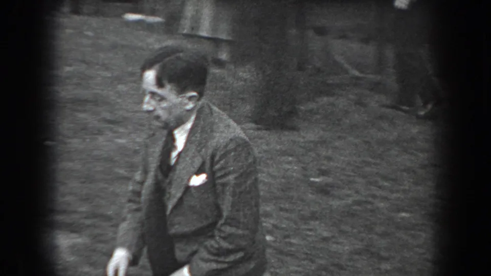 A suited man crosses the grassy park area in this 1938 Reading, Pennsylvania 8mm frame.