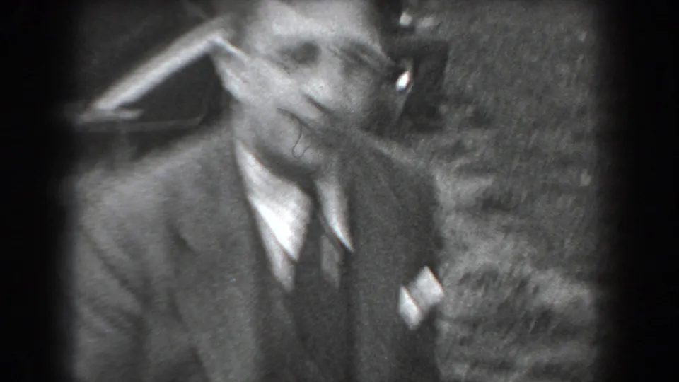 A smiling man in a suit and tie faces the camera in soft 1938 home-movie footage from Reading, Pennsylvania.