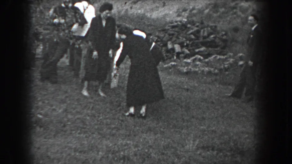 In the final frame, the woman bends forward on the grass while suited adults look on near trees and a low stone wall in Reading, Pennsylvania, 1938.