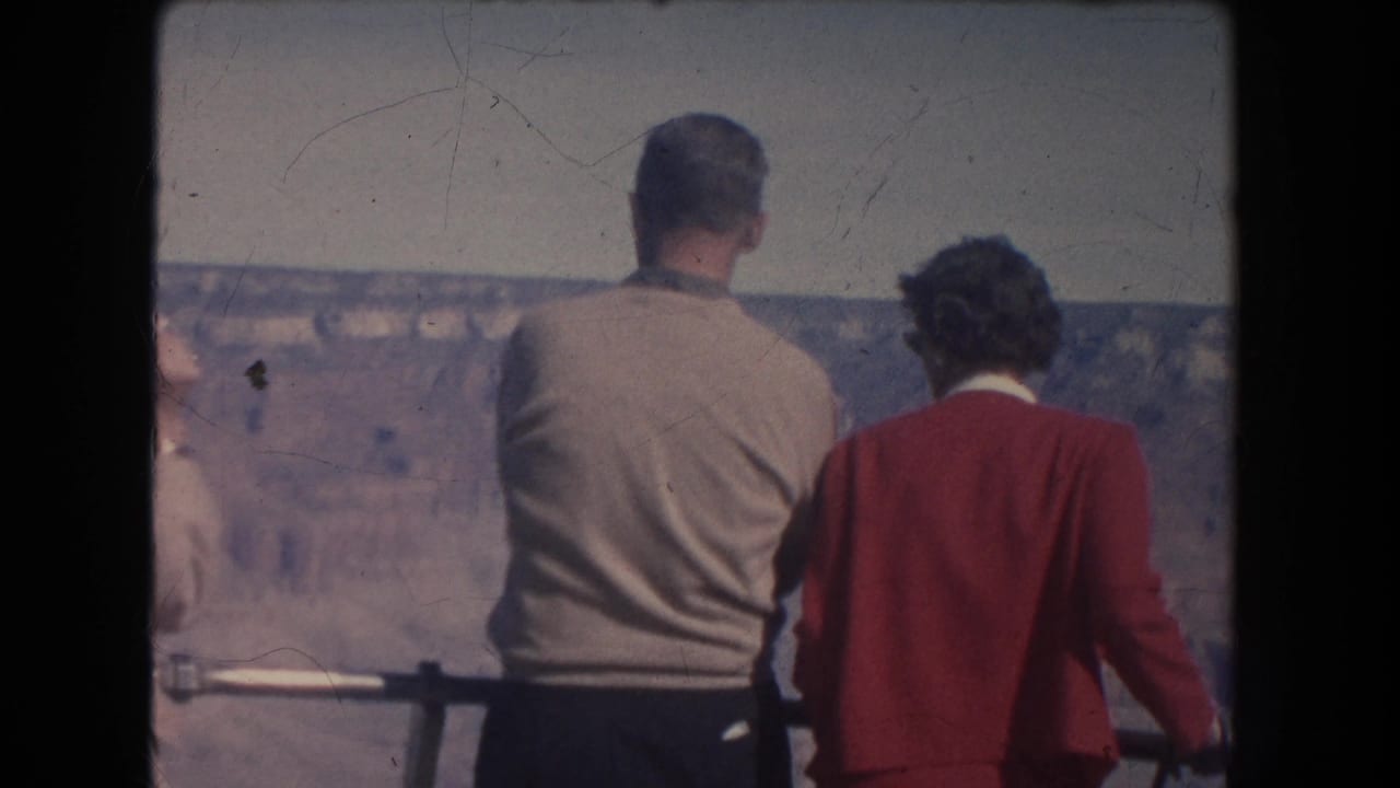 1951 home-movie frame of three visitors viewed from behind at a canyon overlook railing in New Mexico metadata.