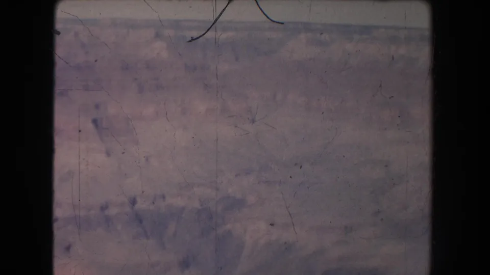 Canyon panorama from the 1951 8mm footage, with soft haze, layered terrain, and visible film wear.