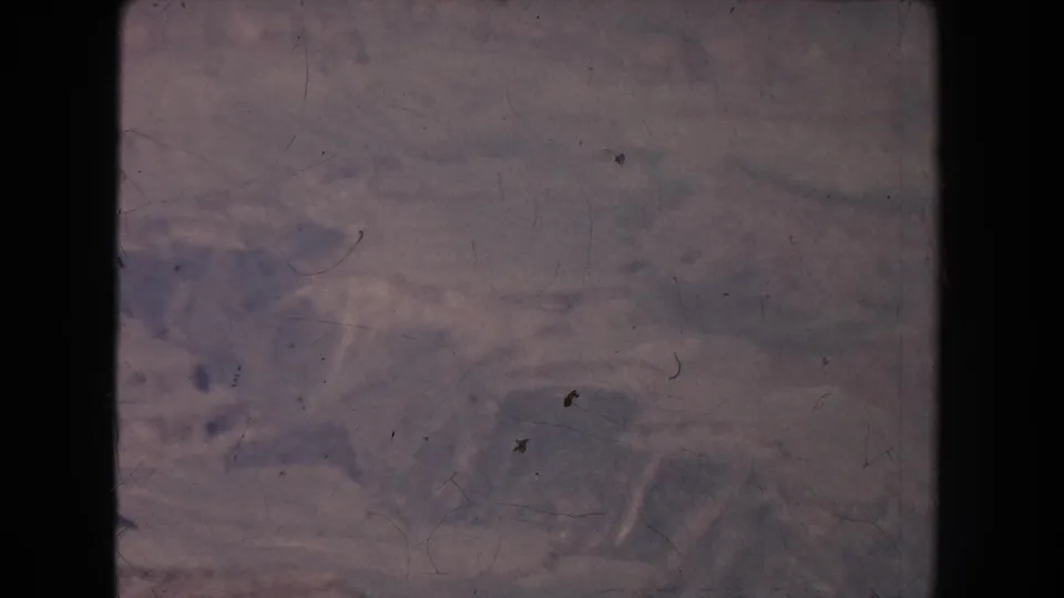 Final 1951 home-movie frame showing a hazy canyon view with layered rock and physical-film marks.