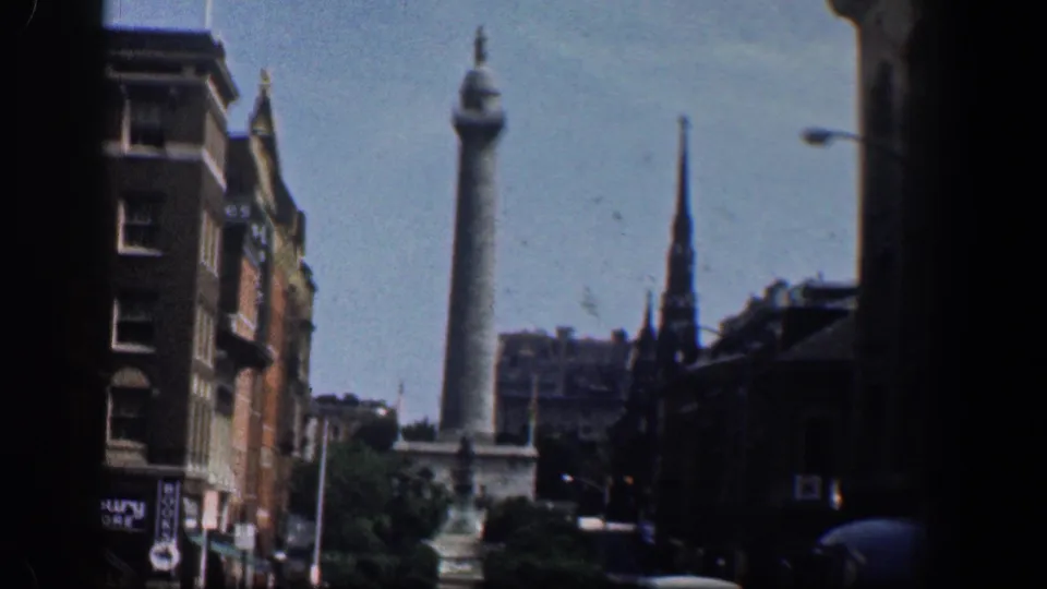 Late frame of the 1961 Washington, DC street view, with a tall monument and steeple above surrounding buildings.