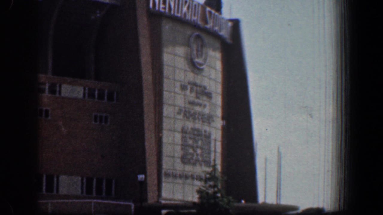 Visitor-shot 1961 view of the Memorial Stadium facade in Washington, DC, with signage, brickwork, windows, and shadowed entry space.