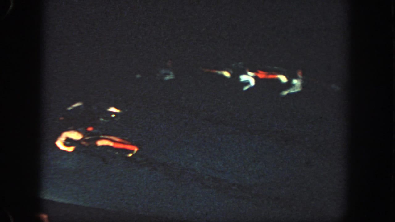 1951 Georgia 8mm frame showing a very dark pool or water surface with red and white light streaks and heavy grain.