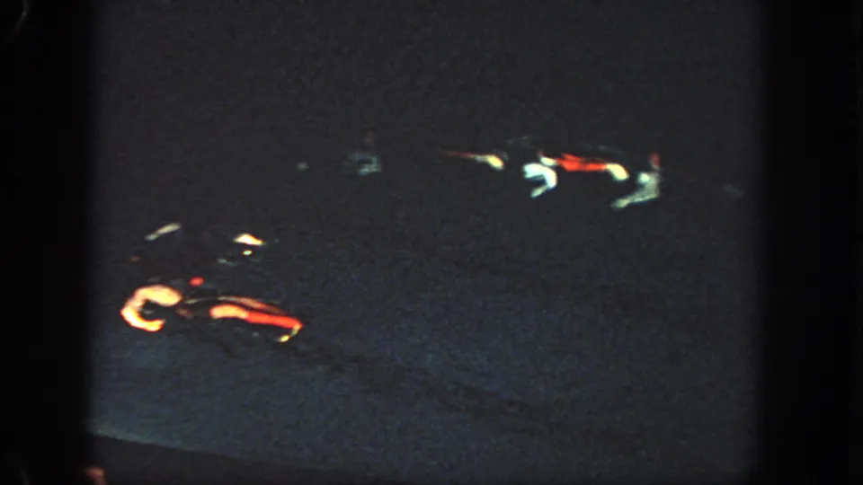 1951 Georgia 8mm frame showing a very dark pool or water surface with red and white light streaks and heavy grain.