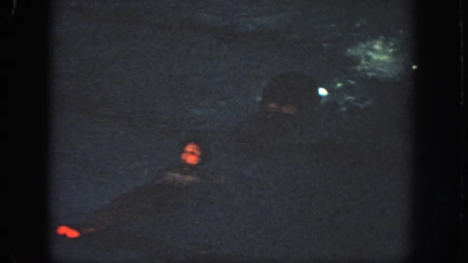 Grainy 1951 Georgia 8mm frame showing a swimmer in dark pool water under low indoor lighting.