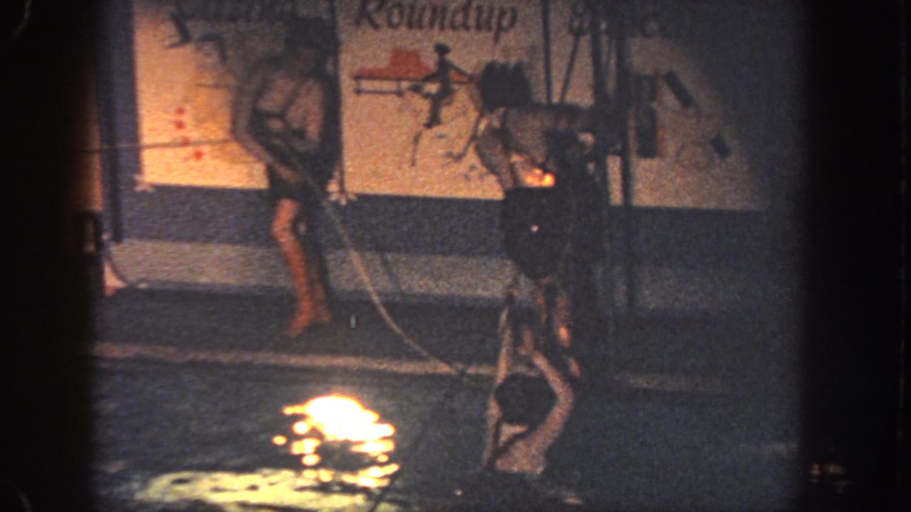 A participant crosses a pool obstacle course in warm, grainy 1951 Georgia 8mm footage with mural lettering behind.