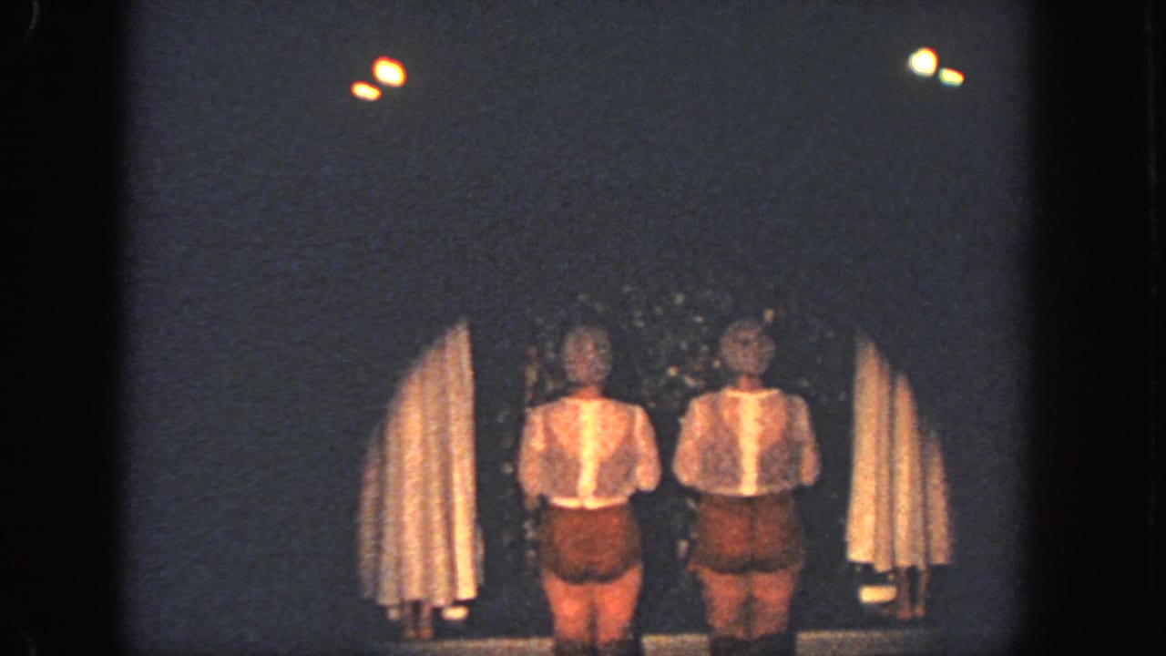 1951 Georgia 8mm frame of two performers in matching brown and white costumes on a dim stage.