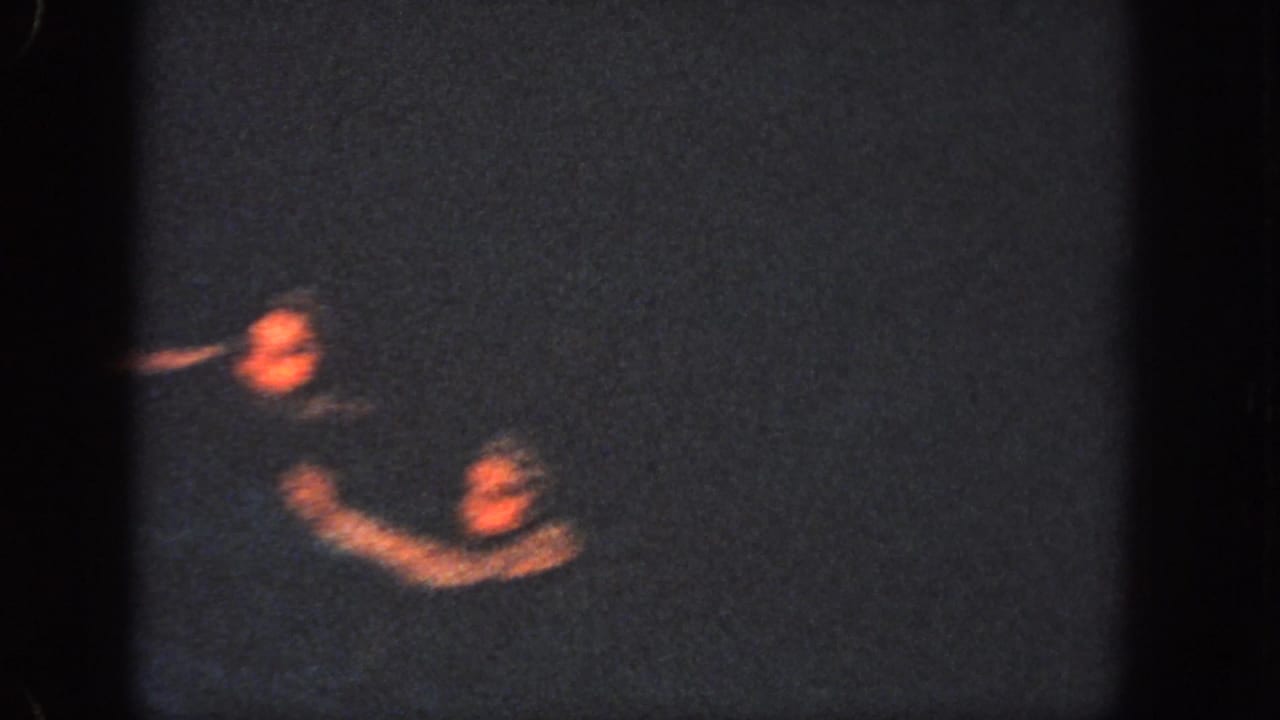 Two swimmers surface in a low-light Georgia pool, their arms blurred by motion during the 1951 routine.