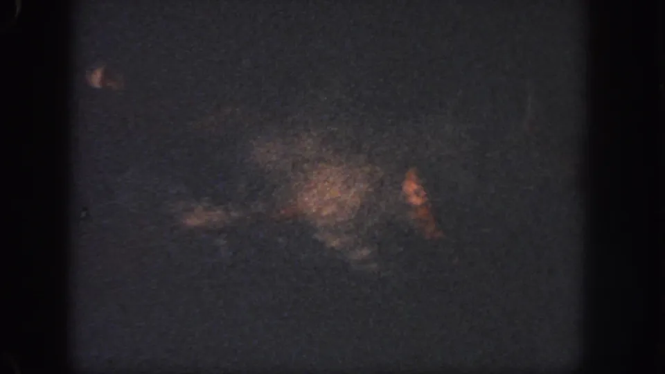 Low-light 1951 Georgia 8mm frame with dark water, soft orange-brown staining, grain, and edge shadows.