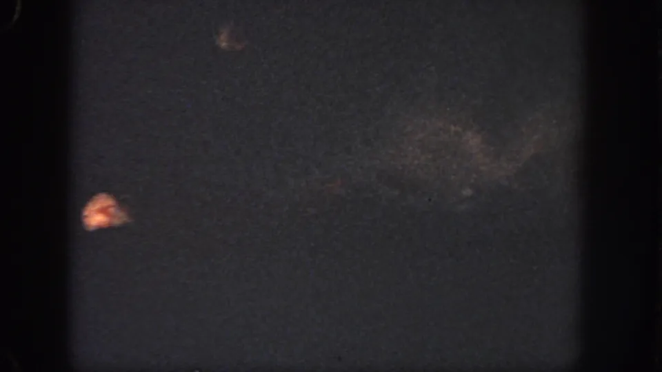 1951 Georgia 8mm frame showing murky water, faint indistinct shapes, a small orange highlight, and film wear.