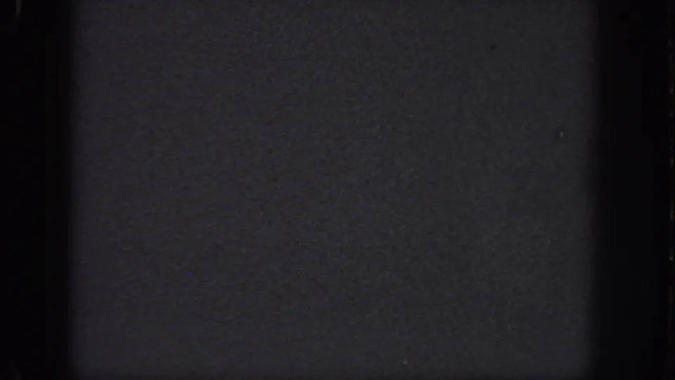 Dark color 8mm frame from the 1951 Georgia clip, showing grain, edge shadowing, and a nearly featureless surface.