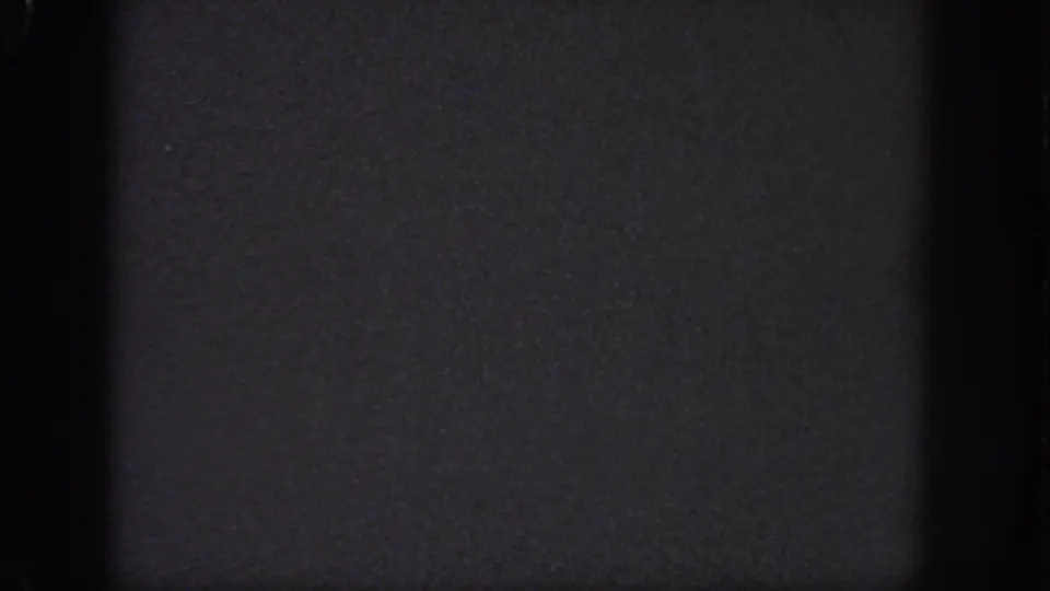 Dark 1951 Georgia-sourced 8mm frame with visible grain, vertical gate bands, and a subtle horizontal frame line.
