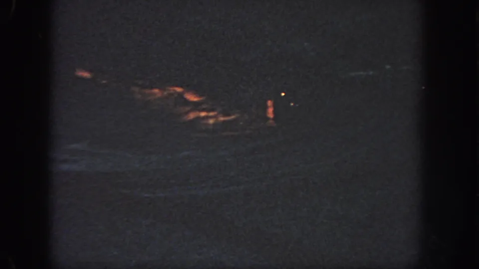 1951 Georgia footage metadata supports a dark offshore night scene with a distant orange flotation shape on rough water.