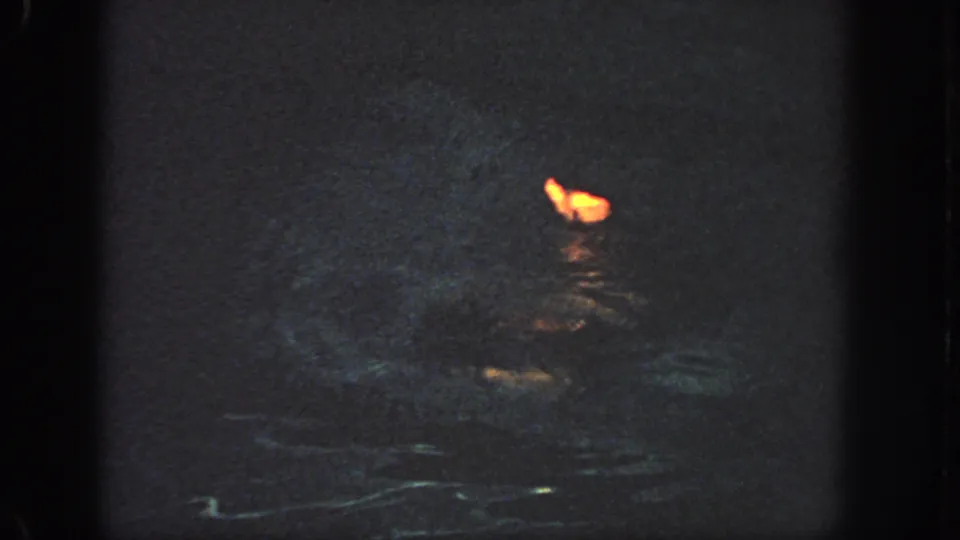 Near the end of the clip, the orange flotation shape sits low on dark water with only faint surrounding detail visible.