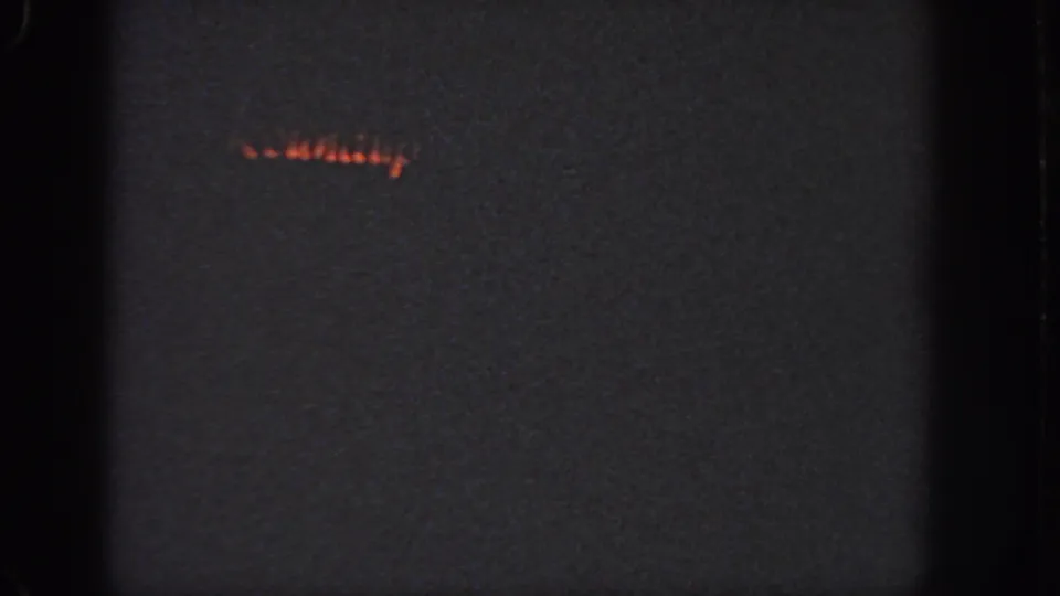Georgia 1951 home-movie frame showing a dim orange glow against a dark, grainy night scene.