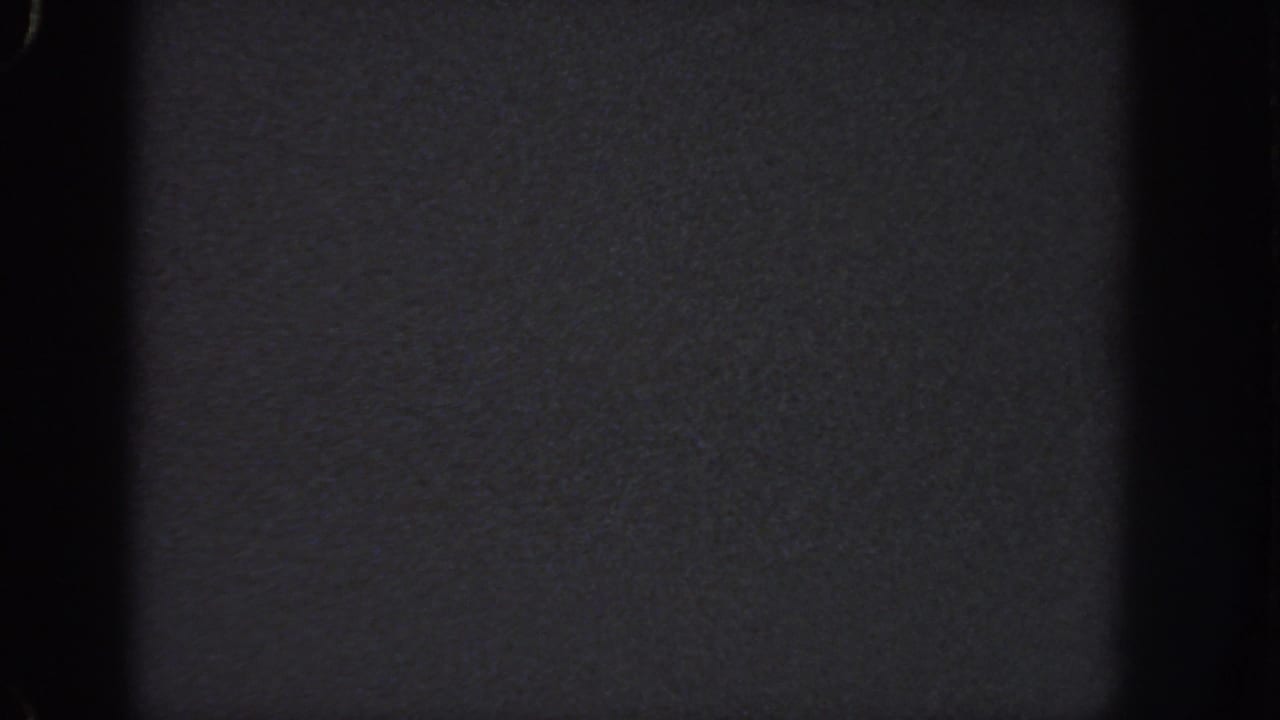 Near-black 8mm home-movie frame from Georgia, 1951, with grain and gate-edge shadows dominating the view.