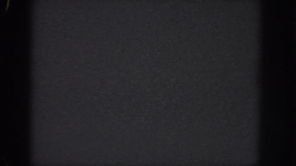 Near-black 8mm home-movie frame from Georgia, 1951, with grain and gate-edge shadows dominating the view.