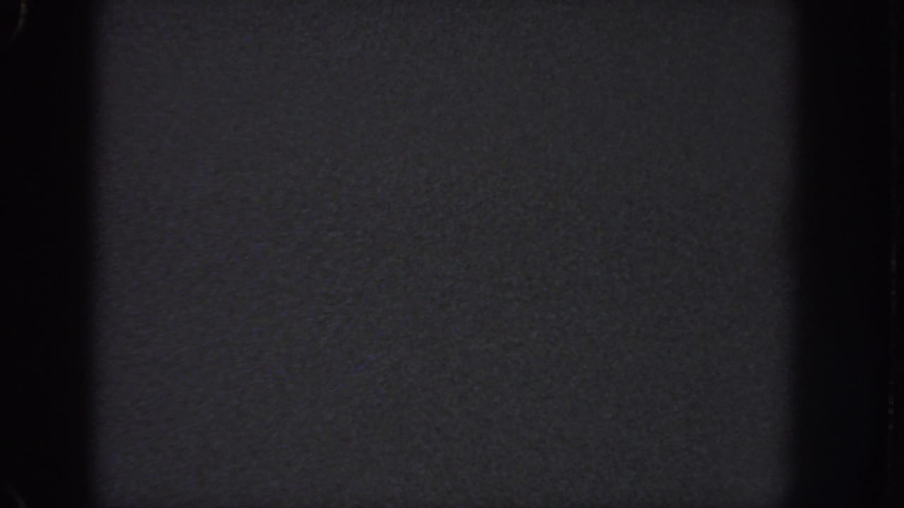Dark blank film area with coarse grain and black vertical borders.