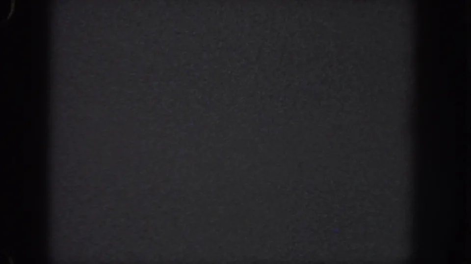 Nearly black 1951 Georgia 8mm frame showing film texture, shadowed edges, and no visible figures or setting.