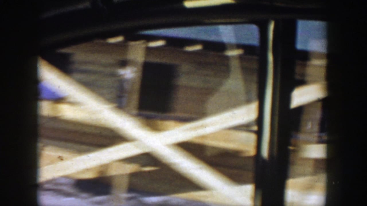 Moving 8mm view of wooden beams, bridge supports, and railings in Grand Rapids, Michigan, 1956.