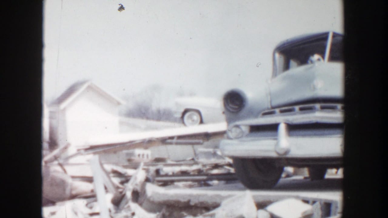 Vintage car raised above broken boards and debris.