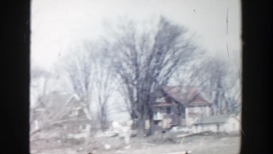 Grand Rapids residential view from 1956 with a small house behind bare trees and muted 8mm color.