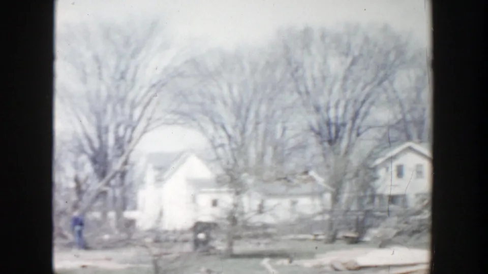 Grand Rapids 1956 home-movie view of a white house, large leafless trees, and a quiet residential frontage.