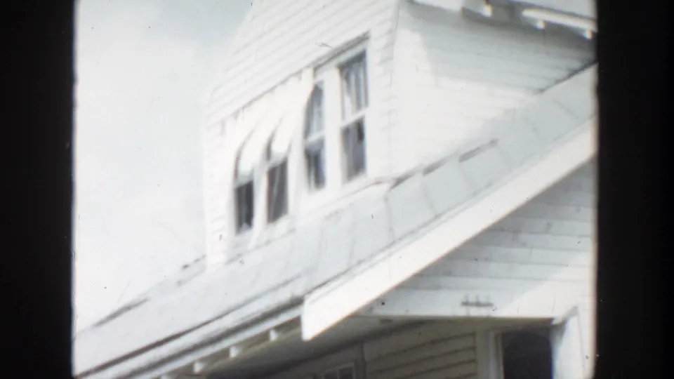 1956 Grand Rapids frame showing upper windows, clapboard siding, and a porch roof on a two-story house.