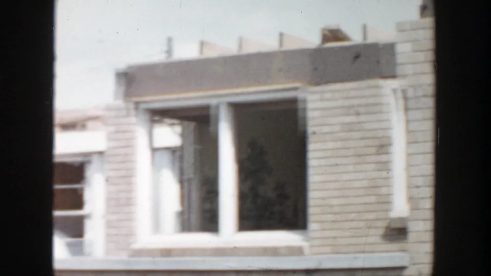 1956 Grand Rapids 8mm frame showing a brick residential facade with upper windows and soft handheld framing.