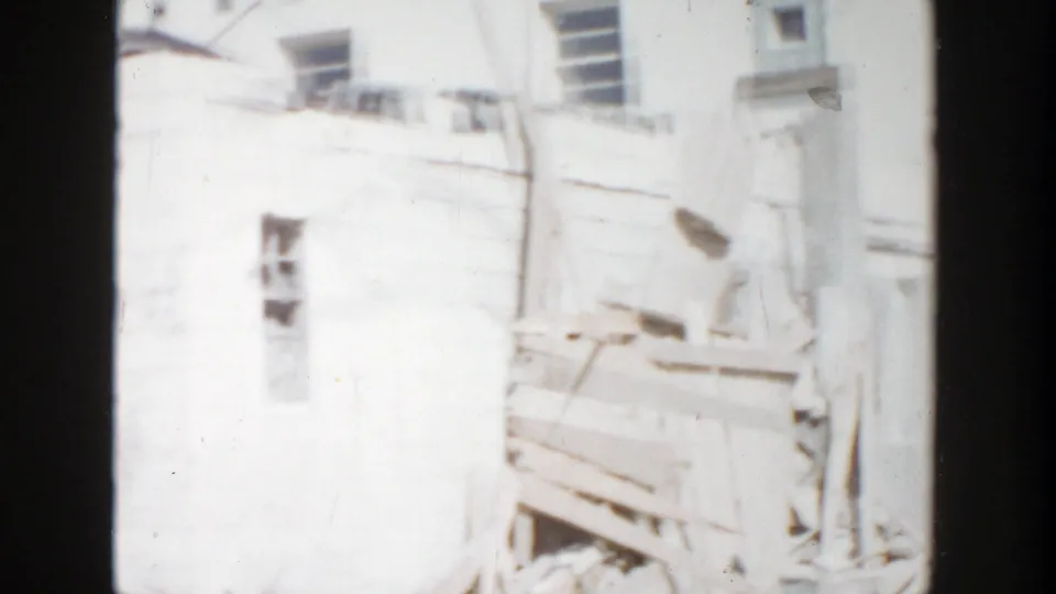 Home-movie frame showing a damaged building exterior and windows in Grand Rapids, Michigan, in 1956.